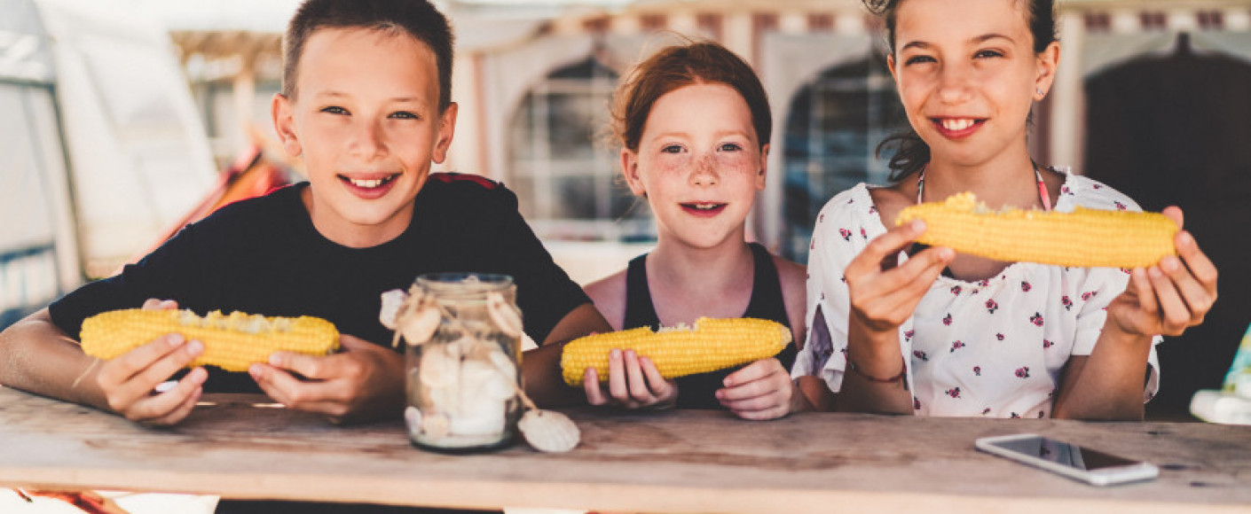 Kids enjoying sweet corn on the cob