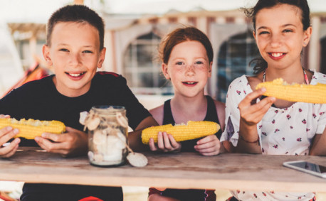 Kids enjoying sweet corn on the cob